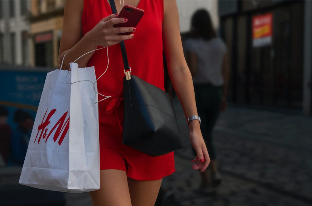 Woman in a red dress holding a bag from H&M